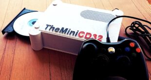 A gaming console with a controller and CD.