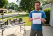 Man holding Nintendo letter outside with video games.