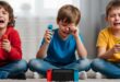 Three upset children playing video games indoors.