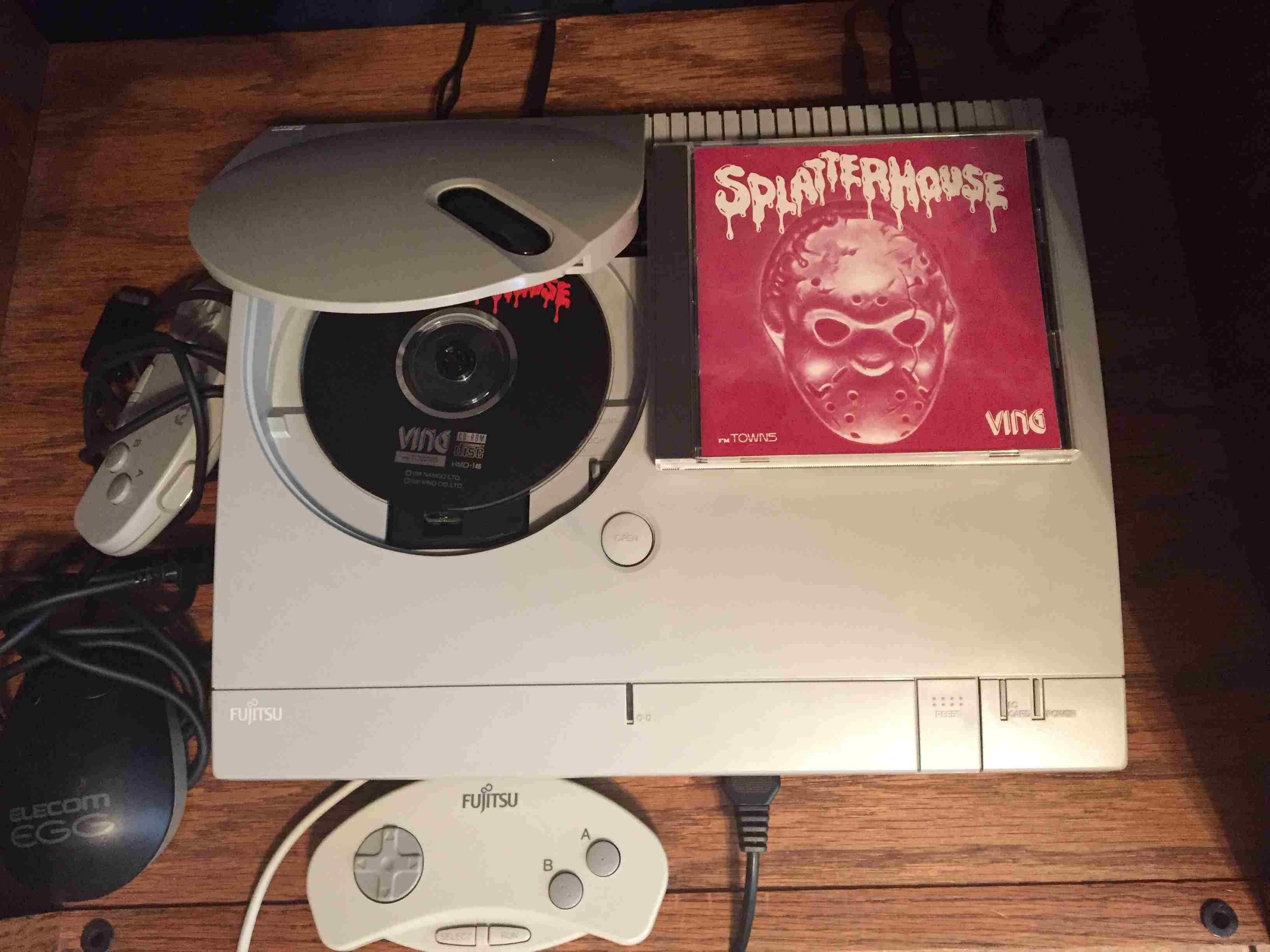 Fujitsu gaming console with Splatterhouse game disc.