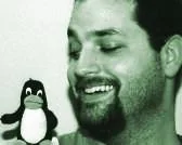 Bill Kendrick holding a Tux penguin plush toy in 2002